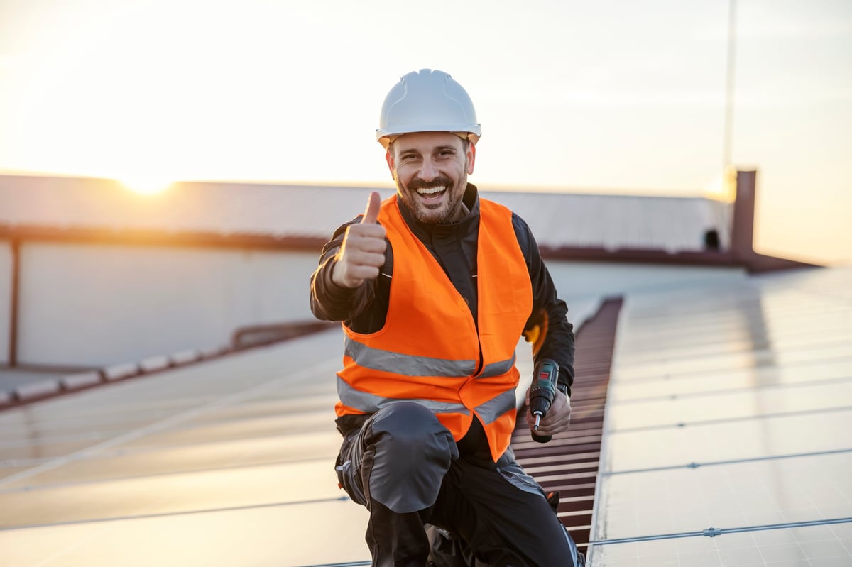 Worker approving solar panels on rooftop