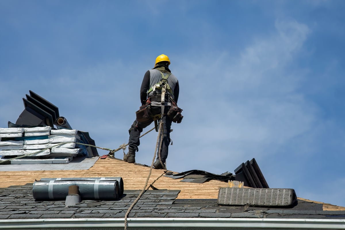 Construction worker using pneumatic nailer and safety helmet