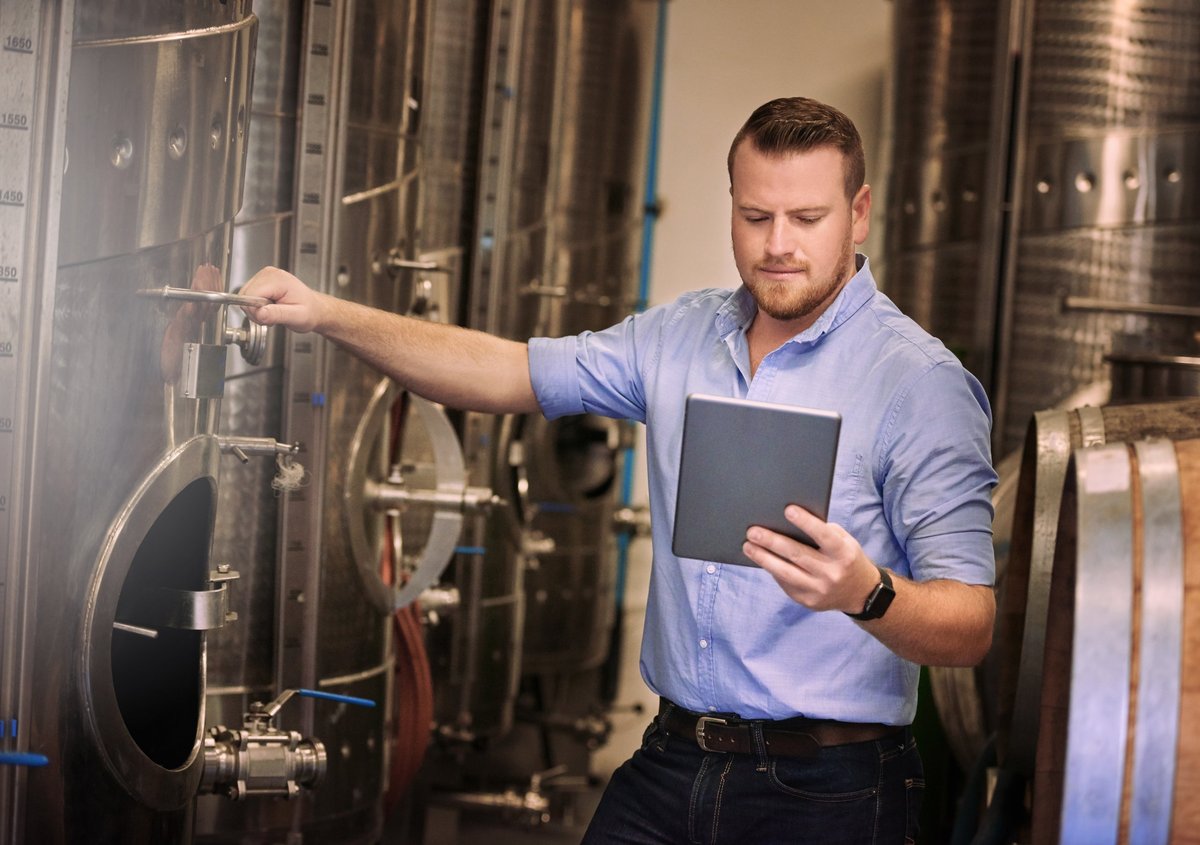 Shot of a male sommelier using his digital tablet at work
